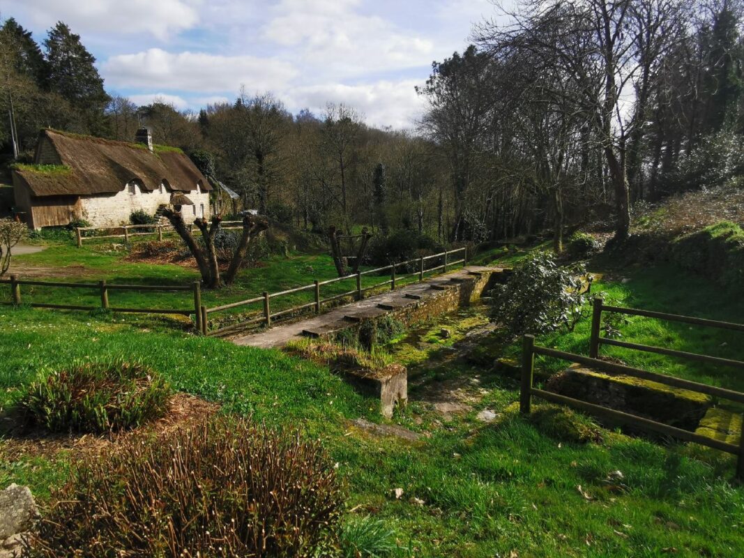 Fontaine et maison en chaume