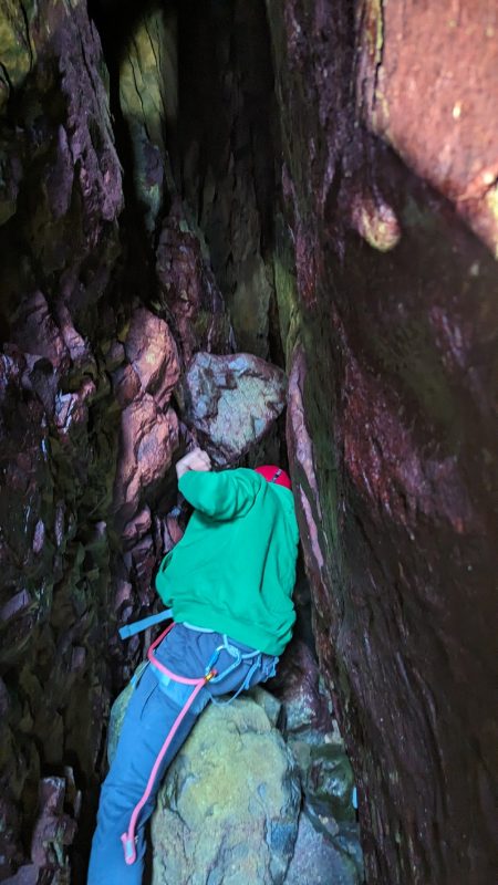 Passage sous un rondin coincé entre les parois