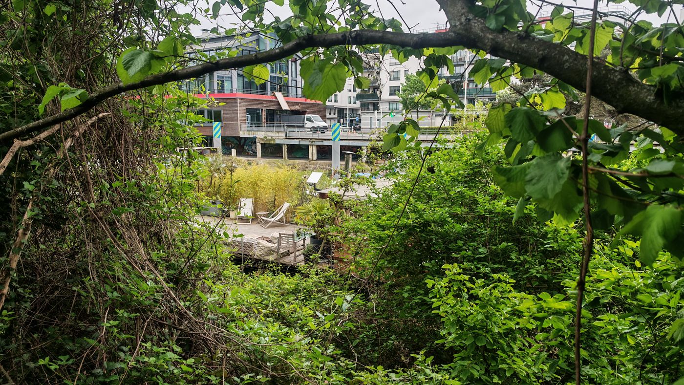 On traverse de la verdure pour rentrer dans une péniche